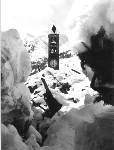 Blick durch die Trümmer auf den Kirchturm von Airolo. Foto: SLF Archiv