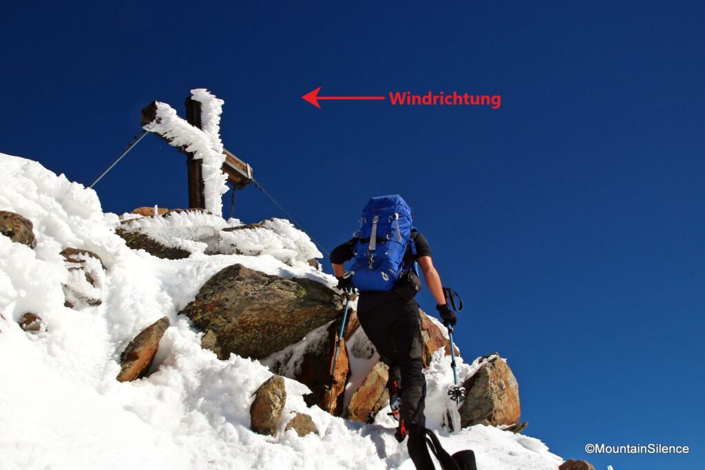 Anraum auf dem Gipfelkreuz und am Fels.