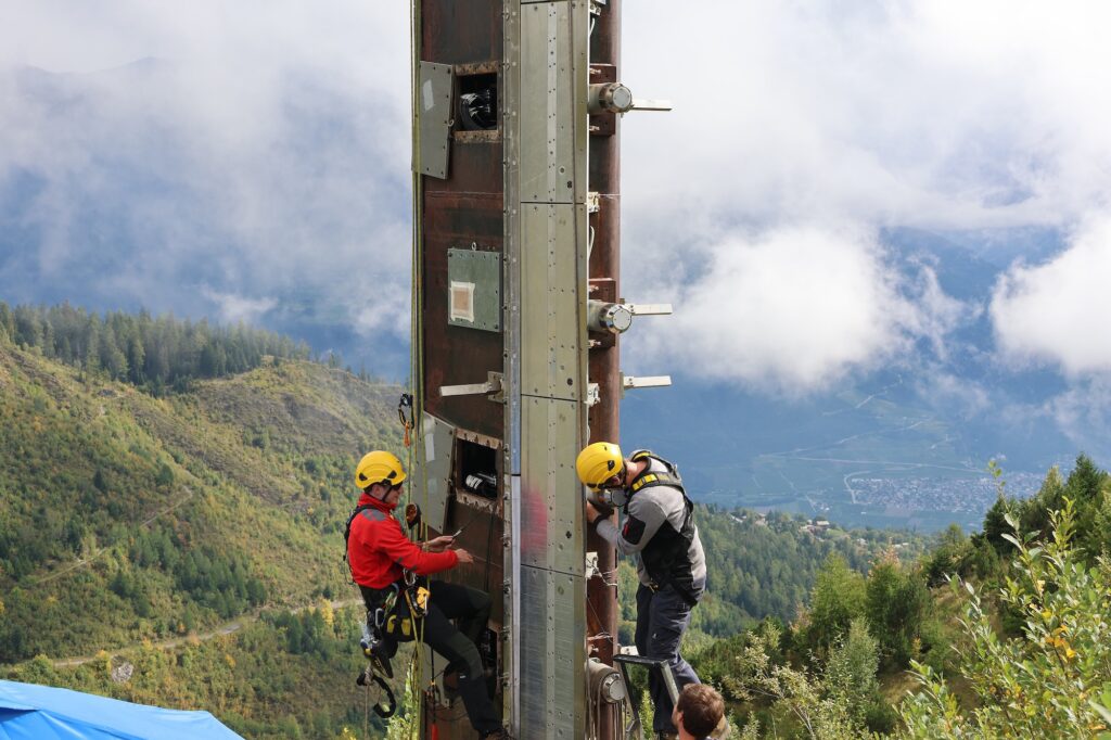 Michael Hohl und Urs Flütsch von der Gruppe Versuchsanlagen bei Arbeiten am 20 Meter hohen Mast. (Foto: Roman Oester / SLF)